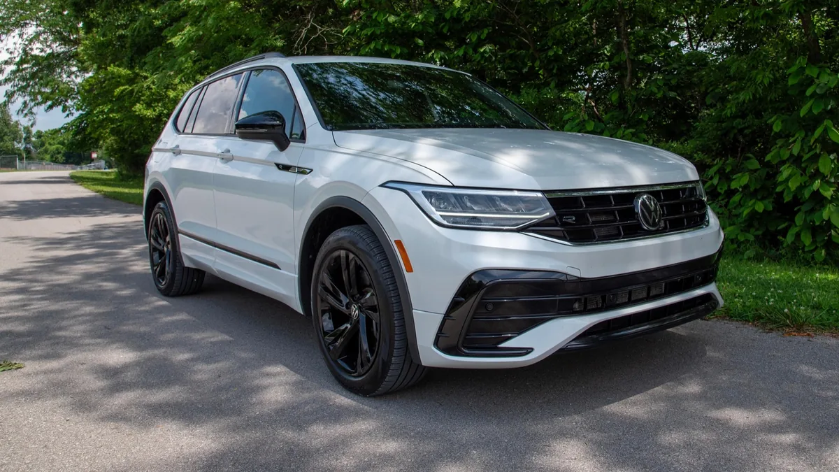 White Volkswagen Tiguan parked on a tree-lined road