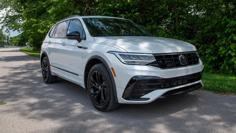 White Volkswagen Tiguan parked on a tree-lined road